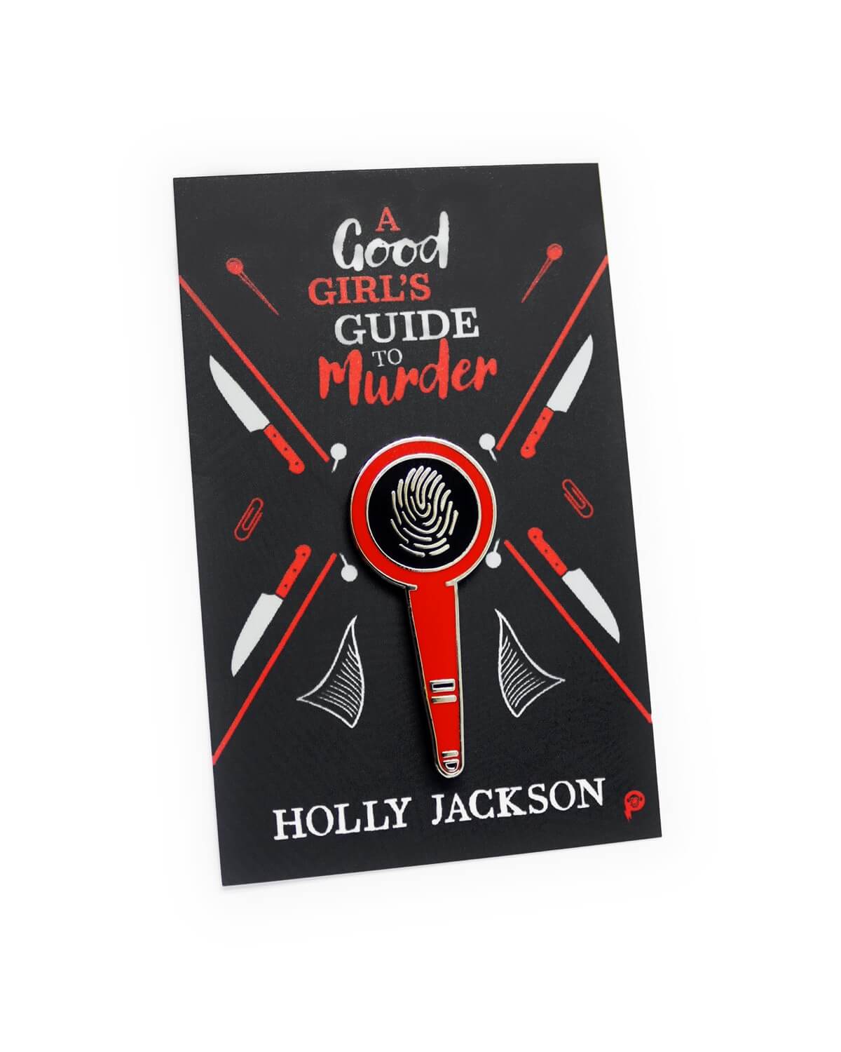 A pin featuring a magnifying glass over a finger print on a backing card for A Good Girl's Guide to Murder by Holly Jackson