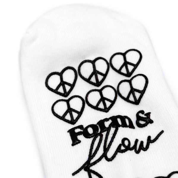 A white grip sock with a black pattern on the bottom that reads 'Form & Flow'.