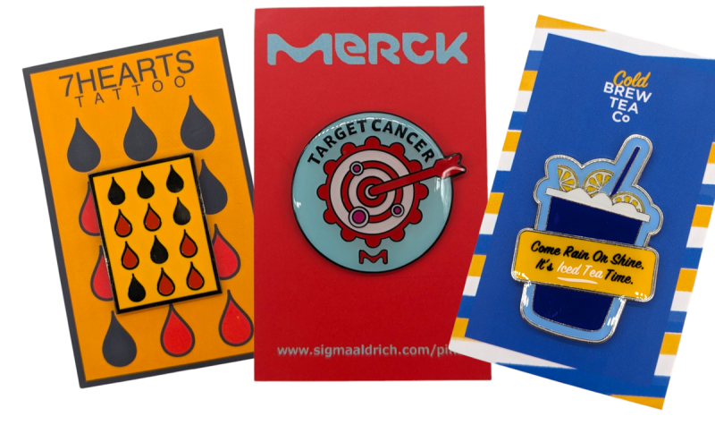 Three pin badges on backing cards that companies use for brand awareness.