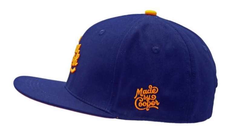 An orange MbC logo on the side of a blue cap.