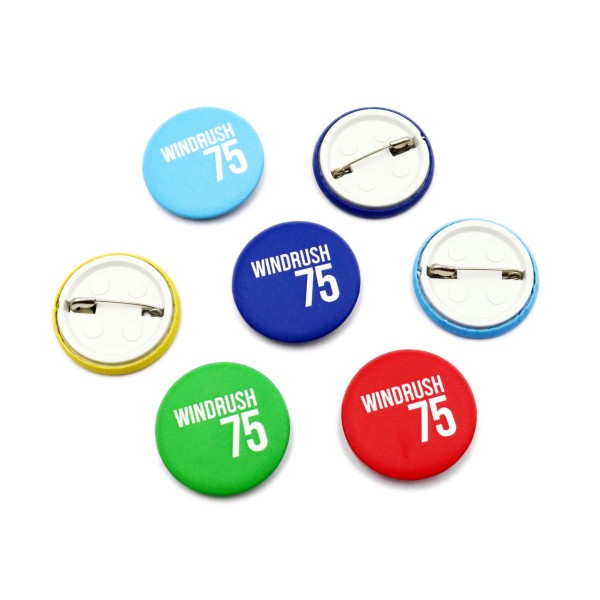 A selection of Windrush 75 custom button badges in different colours.