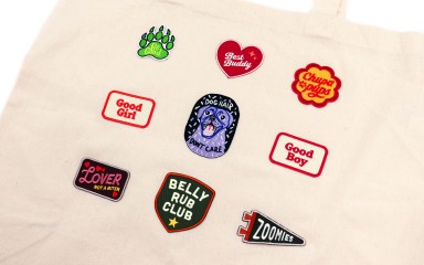 A tote bag with 9 iron-on-patches about dogs and puppies.