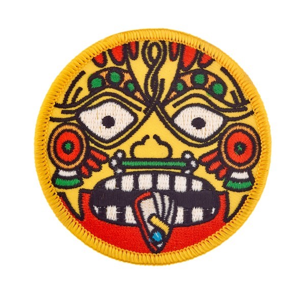 A circular embroidered custom patch. The badge features a terrifying tribal face that looks incredibly angry.