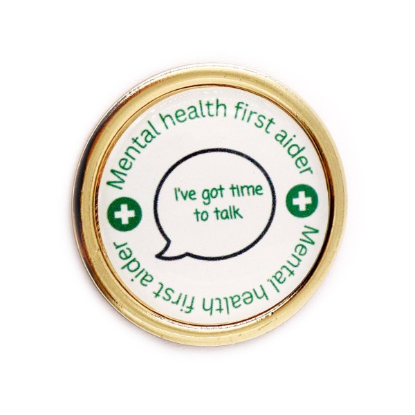 A circular badge with gold edges and white background. The text on the badge reads