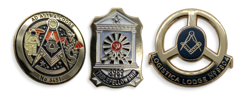 Three masonic pin badges of different designs to represent lodges around the world.