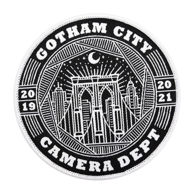 A circular custom patch featuring the skyscape of Gotham City with the words 