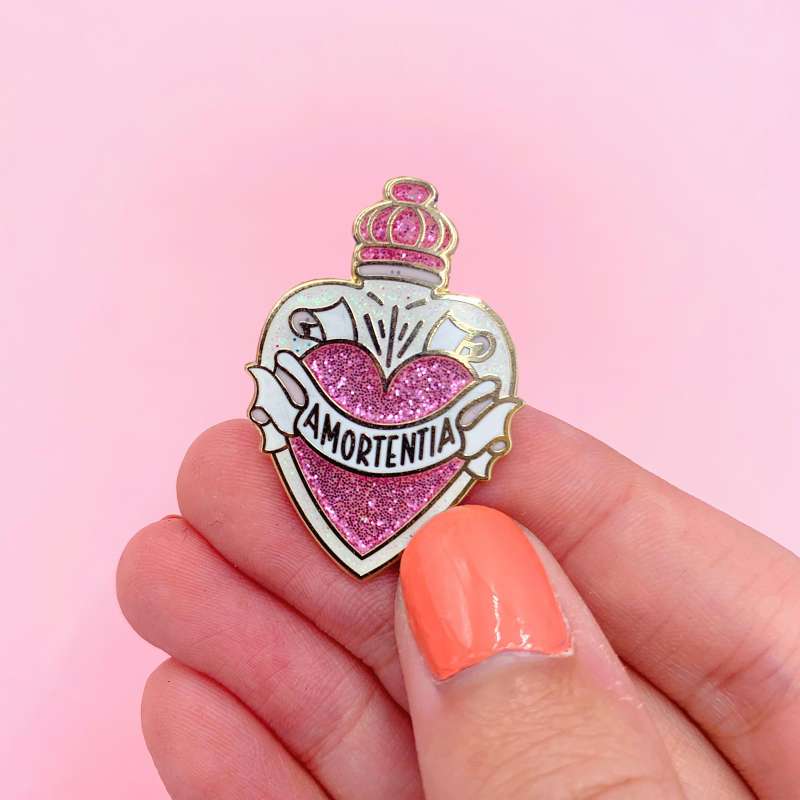 A Harry Potter pin badge. It's a potion bottle with the word Amortentia on the front.