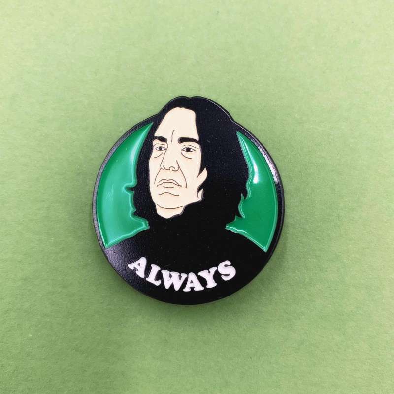 A Severus Snape pin badge from Harry Potter with the word 