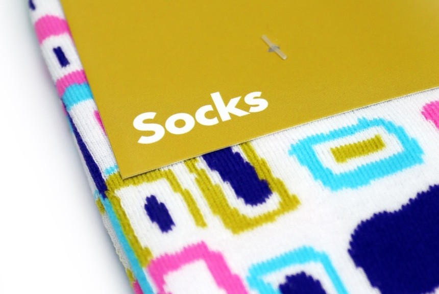 A close up of some brightly coloured socks with a branding card that simply says 