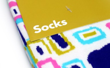 A close up of some brightly coloured socks with a branding card that simply says 