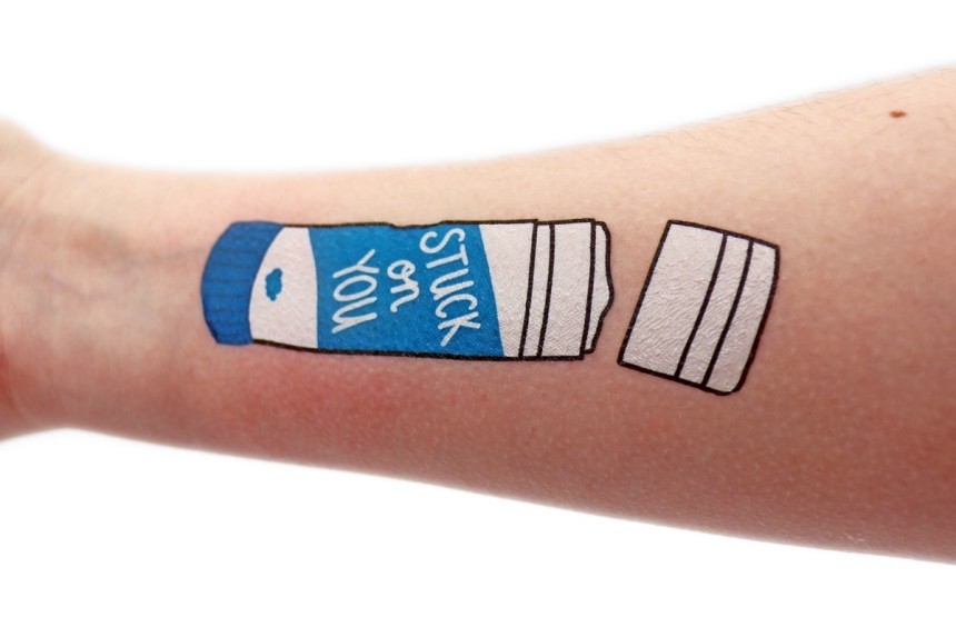 An arm that has a temporary tattoo of a glue stick that says 