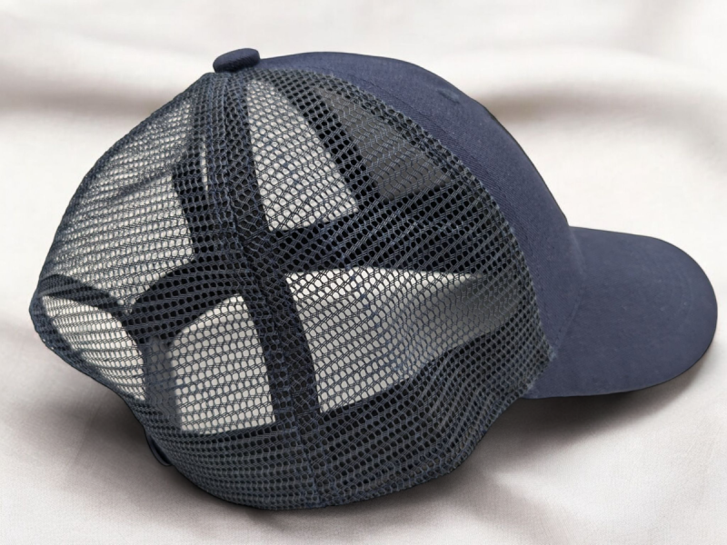 The back of a blue trucker hat showcasing the mesh fabric and snapback closure. 