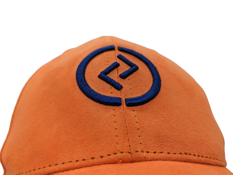 An orange baseball cap with a patterned blue logo.