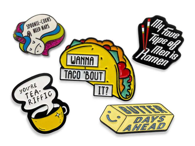 Some hilarious pin badges featuring puns like 'You're tea-riffic, 'Butter Days Ahead', & 'Wanna Taco'bout it?'