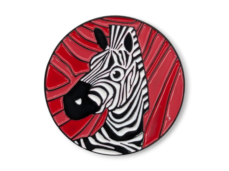 A circular soft enamel pin badge featuring a Zebra with a red background.