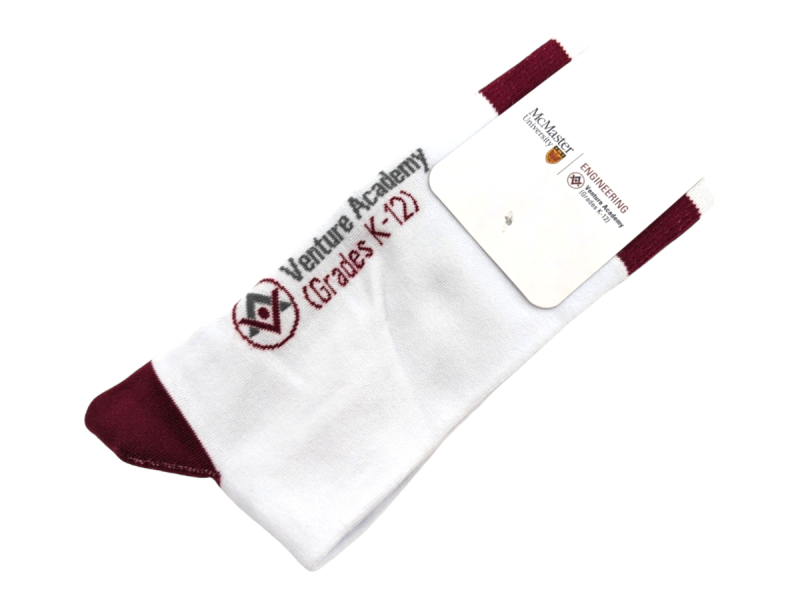 A white pair of socks with burgundy heels and cuffs and a branded packaging card.