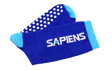 A pair of royal blue grip socks have rubber soles with branding.