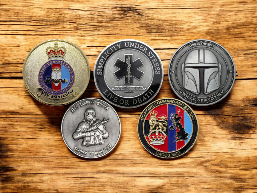 A collection of five challenge coins for military groups, emergency services, and for collecting.