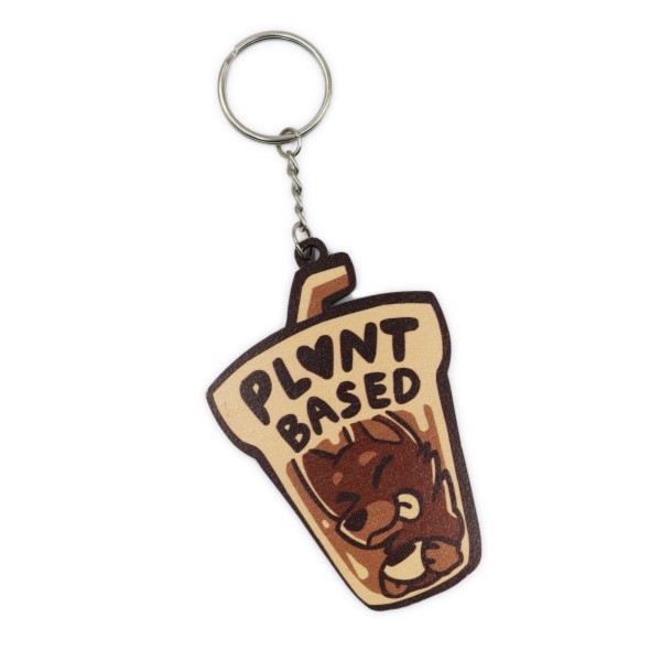 A keyring made of wood in the shape of a takeout coffee mug with a dog UV printed on the front with the words